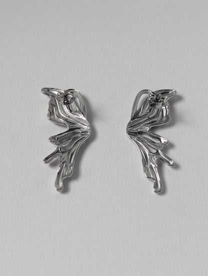 Back view of silver sculptural statement earrings showing stainless‑steel posts and secure butterfly clasp.
