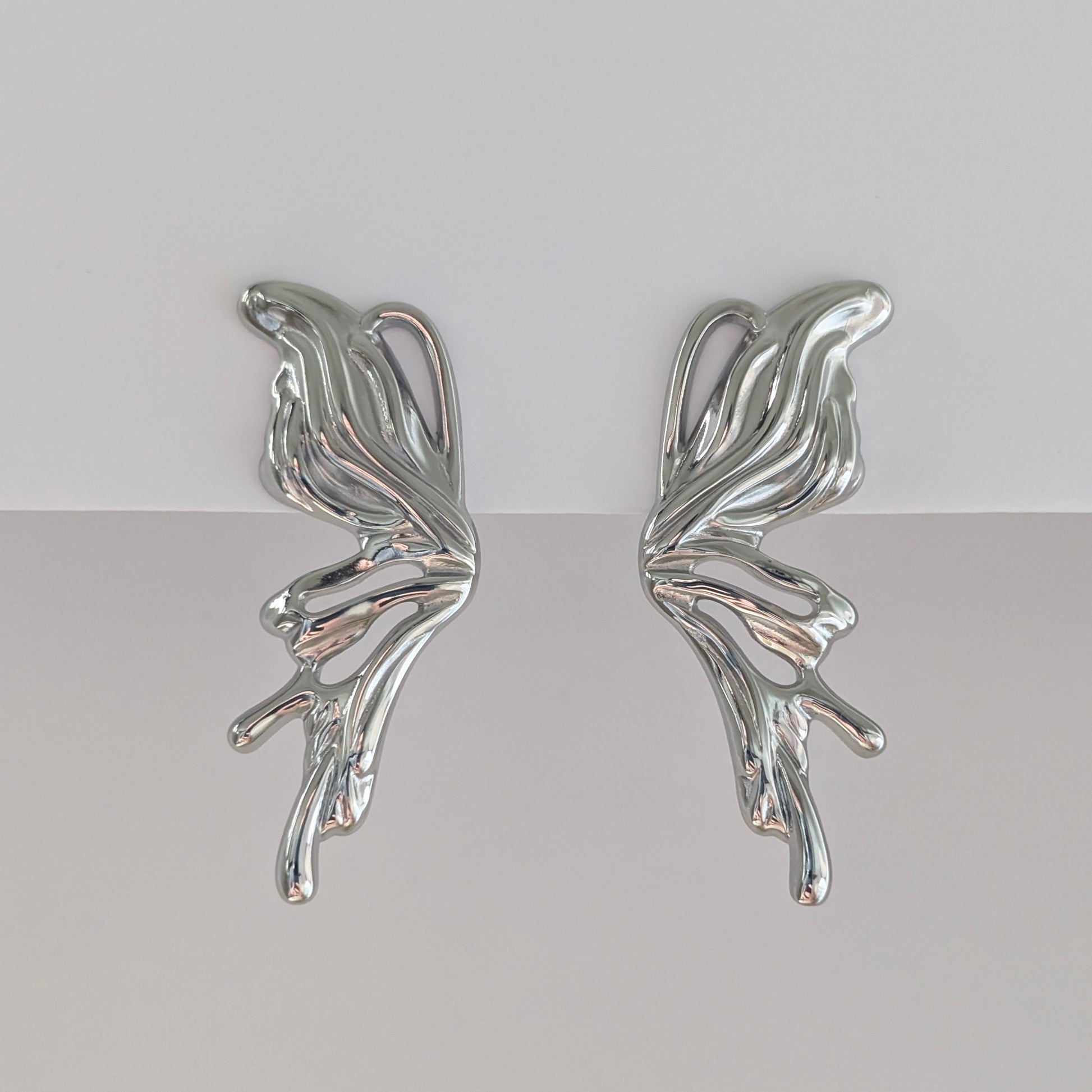 Alternate front angle showing curved silhouette of silver sculptural statement earrings, lightweight 9.3 g pair. 