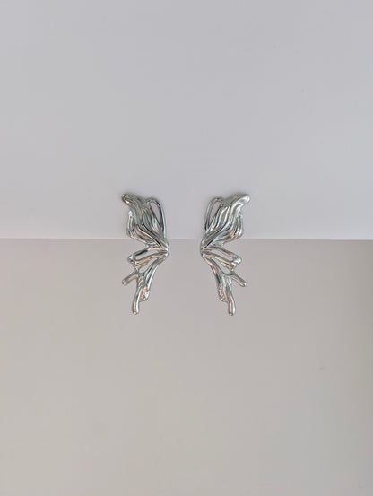 Front view of silver sculptural statement earrings—polished stainless steel, 4.6 × 2.1 cm droplet design.