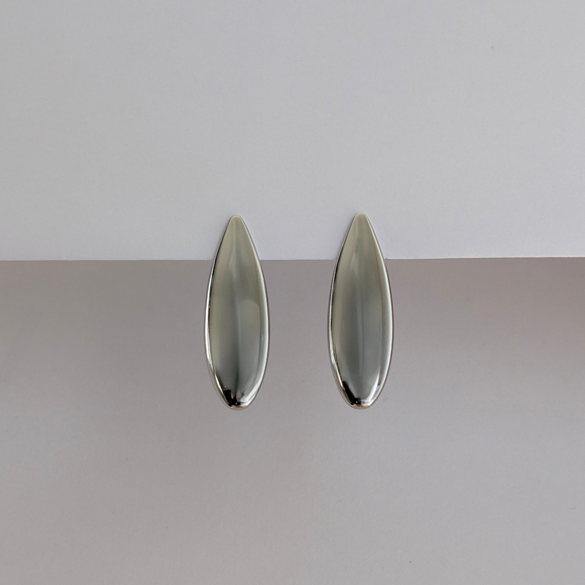 Front view of silver teardrop statement earrings—high‑shine 316 L stainless steel, 1.42 × 4.53 cm.