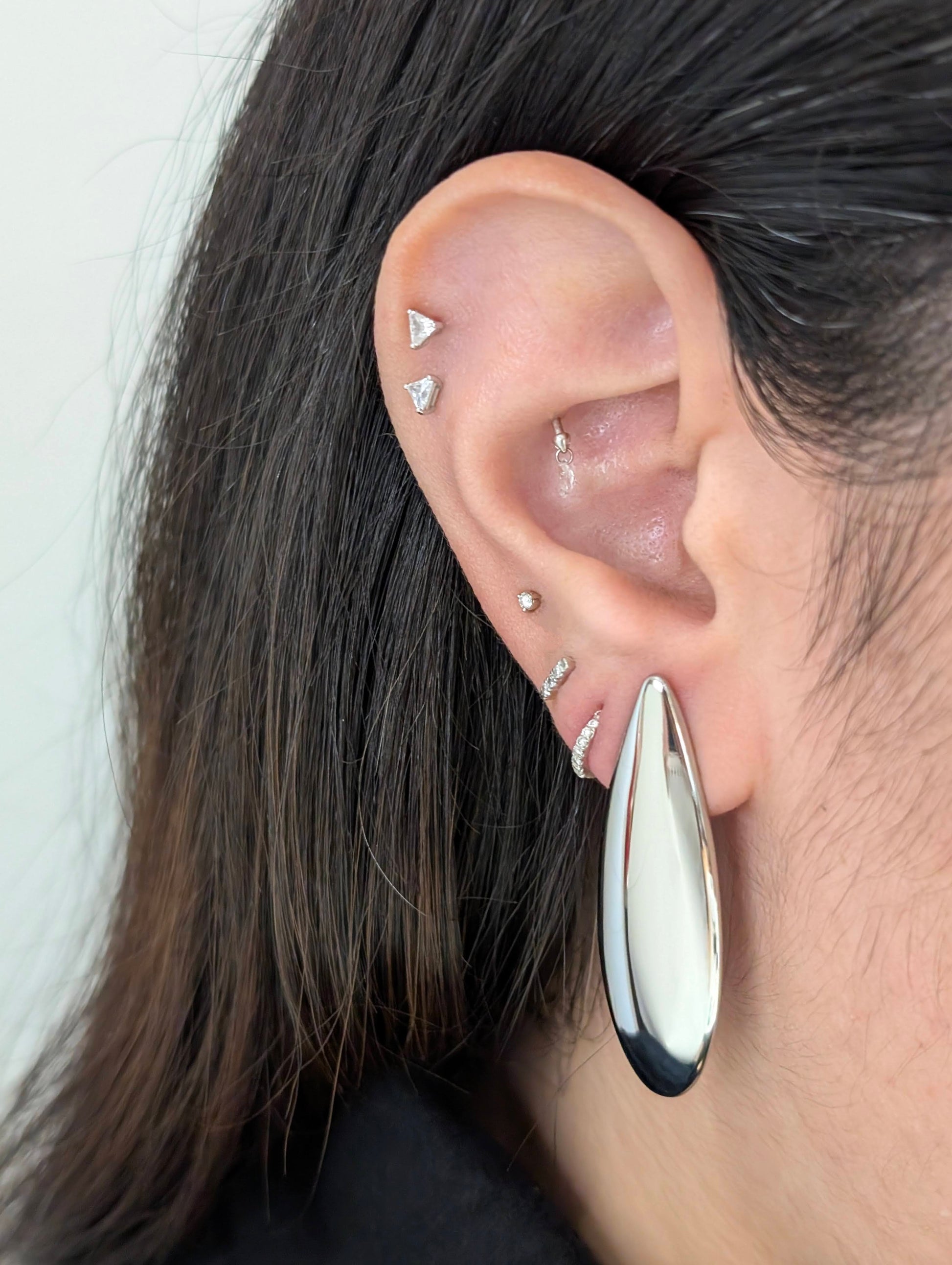 Second on‑ear view of Raya silver teardrop statement earrings, highlighting polished shine and elegant 4.53 cm drop.